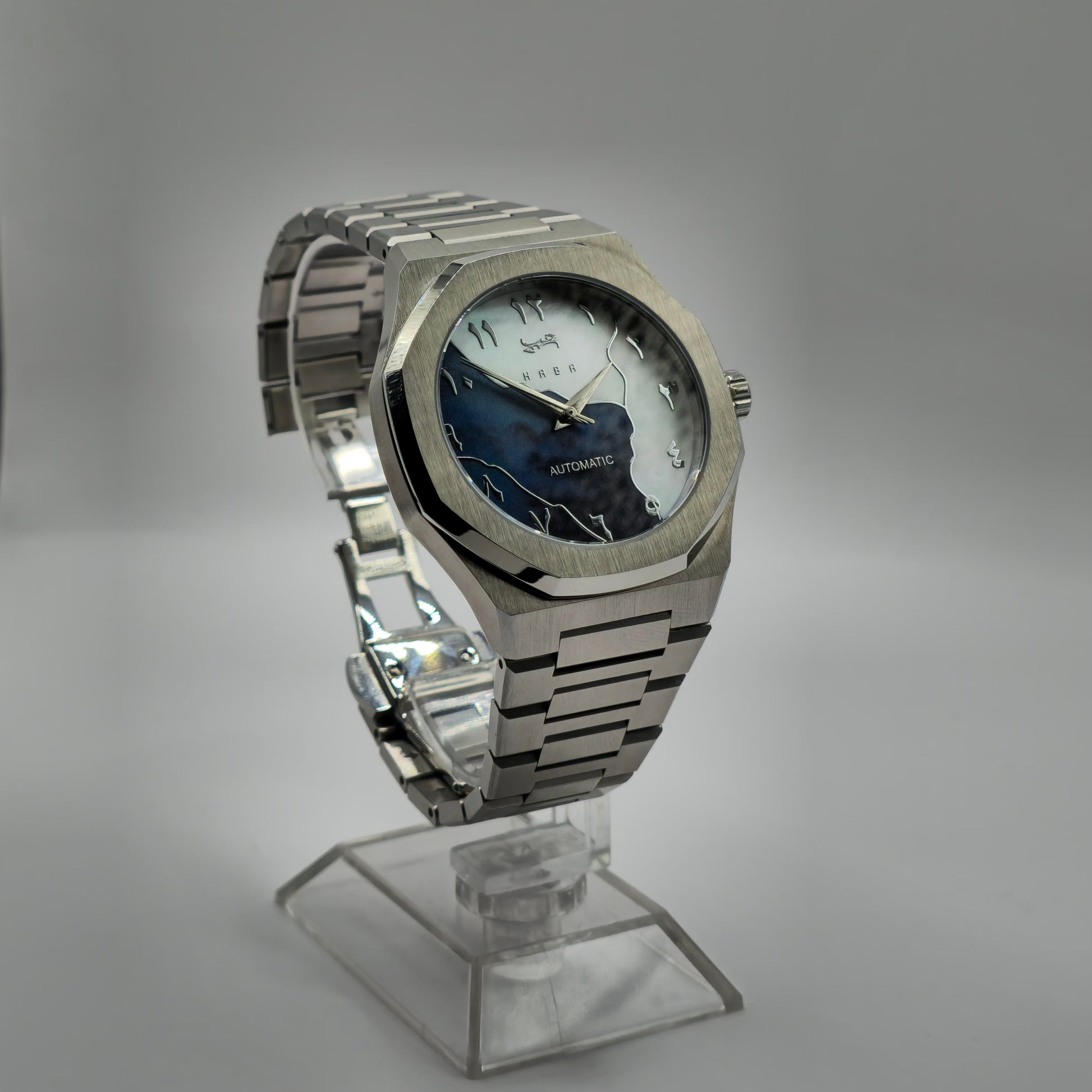 Montre automatique Arabic Dial pour homme avec chiffre arabe et cadran bleu vu de côté et posé sur un support.