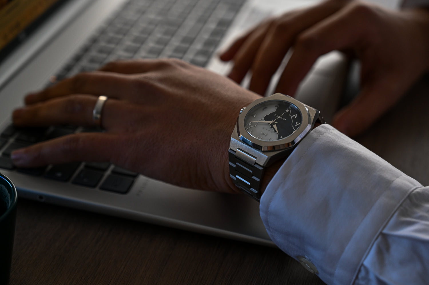 Photo de la montre Arabic Dial avec chiffre arabe de chez HABAOFFICIAL porté par une personne travaillant sur un ordinateur portable