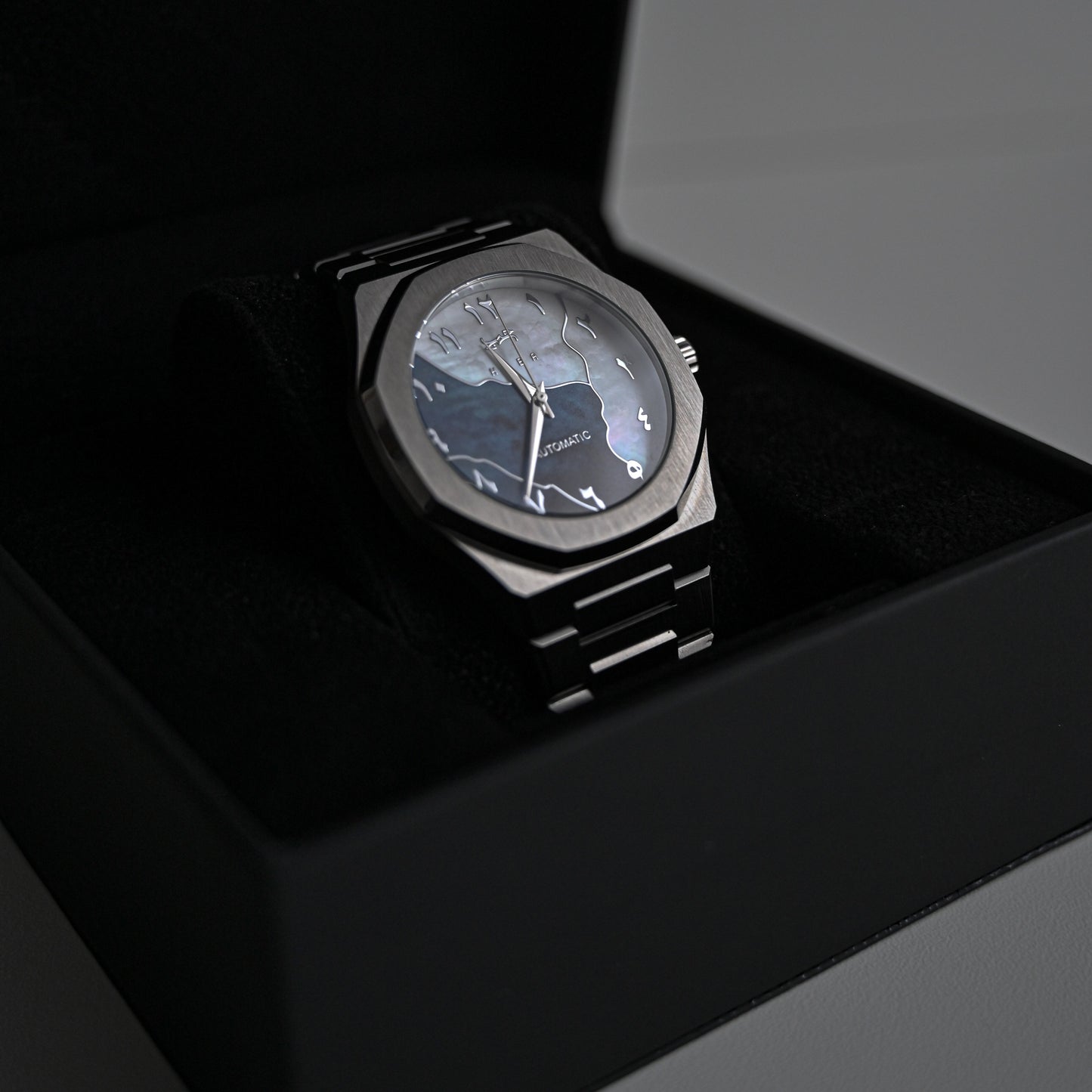 Montre automatique Arabic Dial pour homme avec chiffre arabe et cadran bleu vu de côté et rangé dans sa boite noire et élégante.