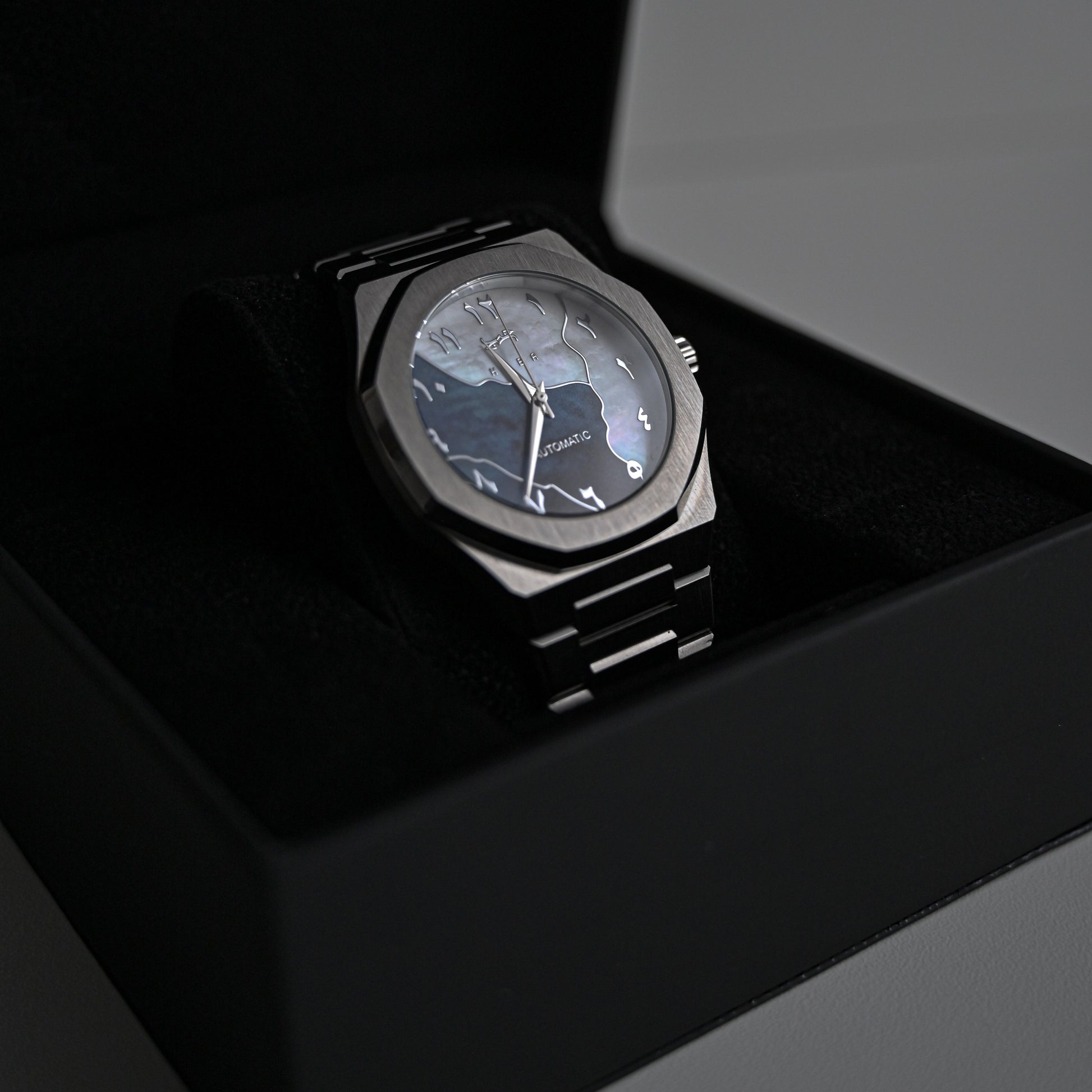 Montre automatique Arabic Dial pour homme avec chiffre arabe et cadran bleu vu de côté et rangé dans sa boite noire et élégante.