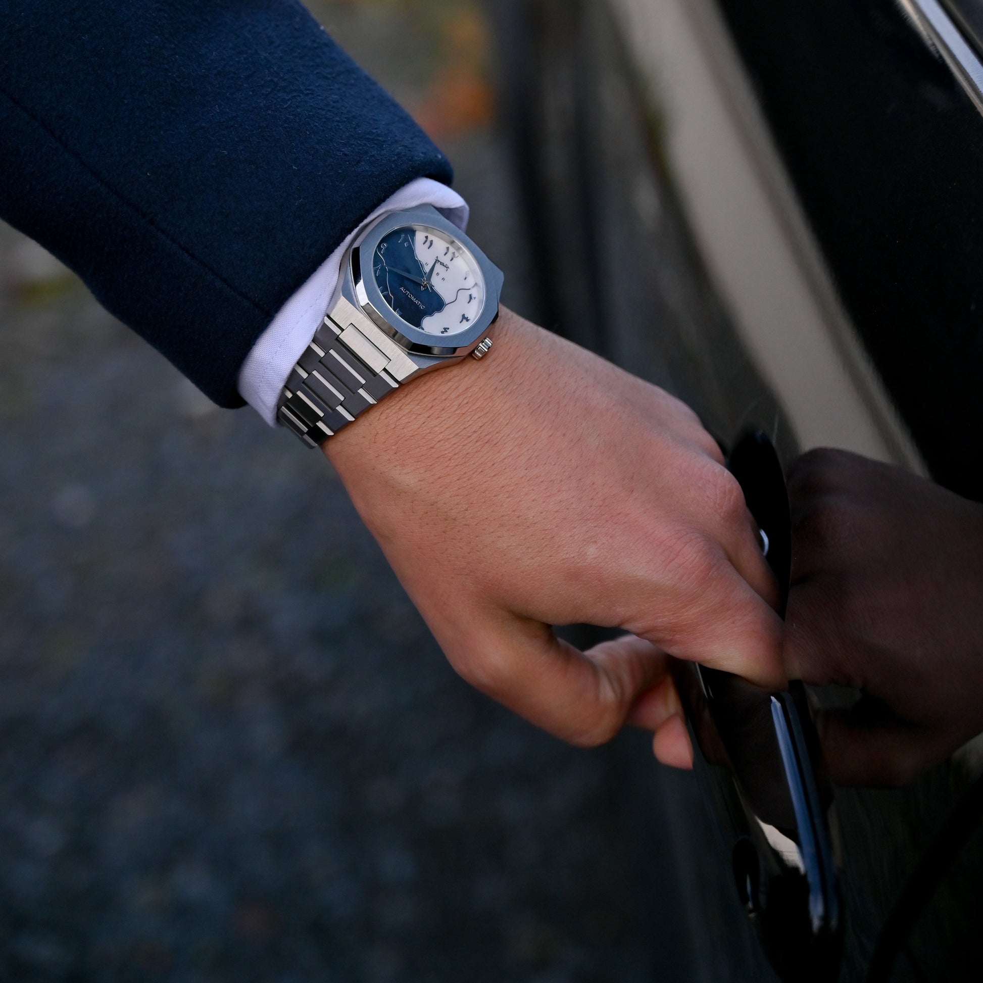 Montre automatique Arabic Dial pour homme avec chiffre arabe et cadran bleu porté au poignée.